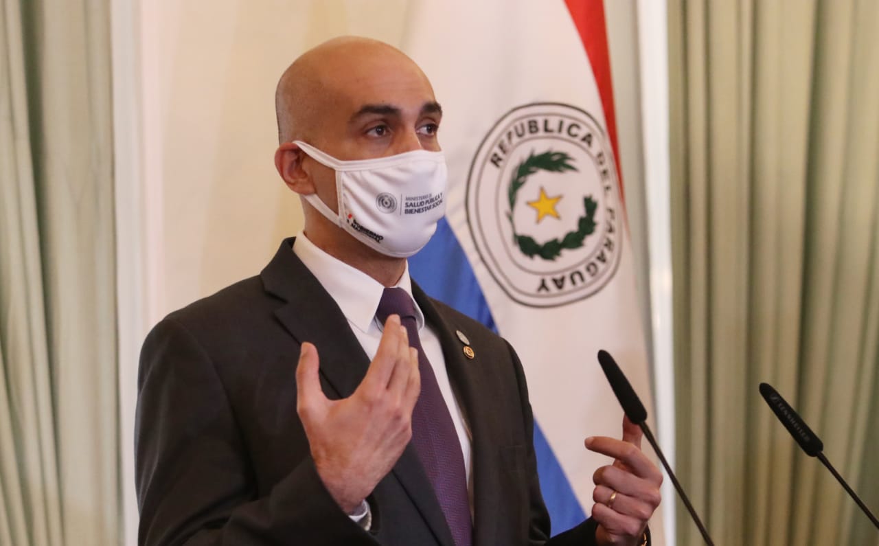 El ministro de Salud, Julio Mazzoleni, dando una conferencia de prensa cubierto con un tapabocas del Ministerio de Salud.
