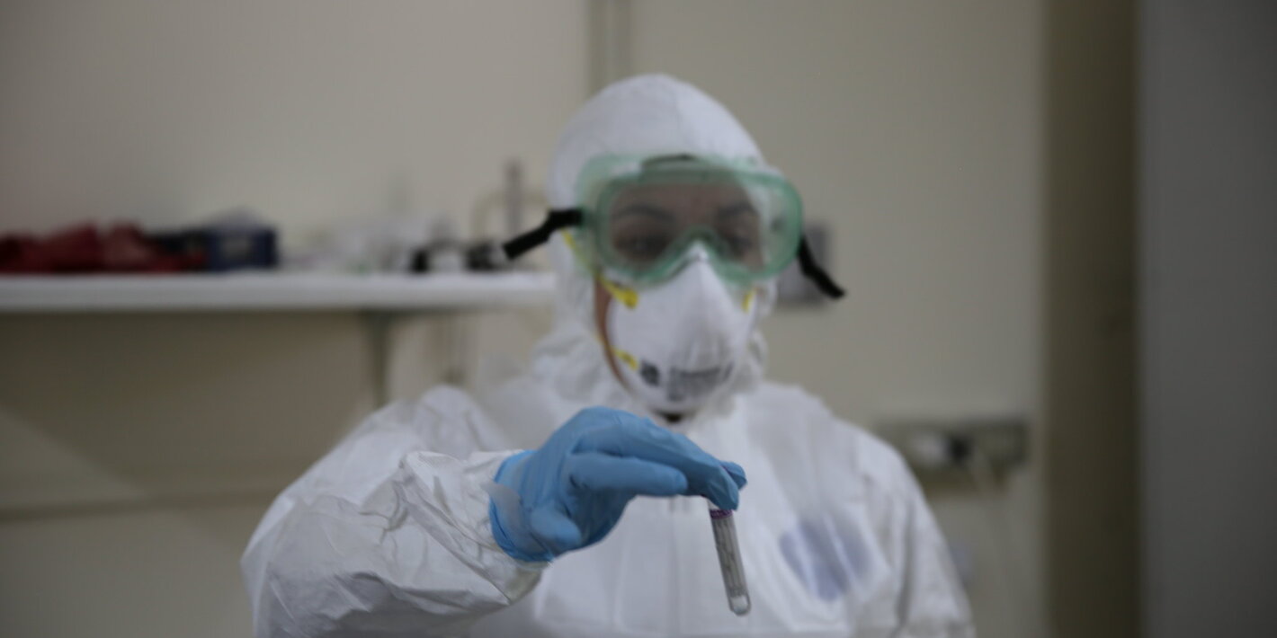 Trabajo con muestra de Covid-19 en el laboratorio, con traje especial de bioseguridad.