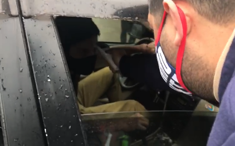Funcionario de Cerro Porteño tomando la temperatura a jugador en su vehículo