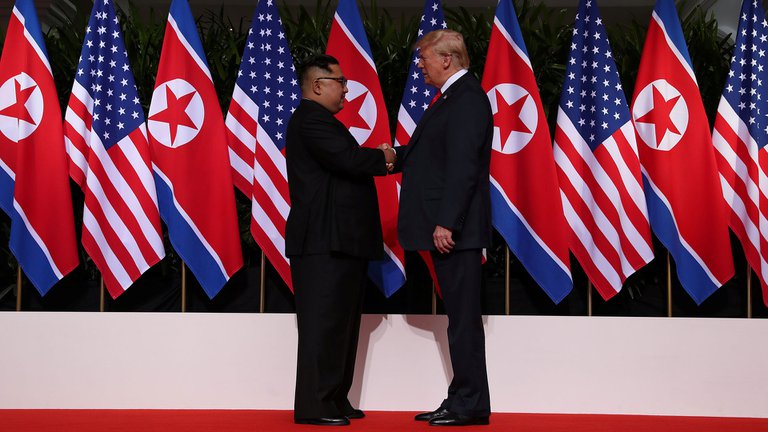Donald Trump y Kim Jong-un pasandose las manos en la cumbre de Singapur.