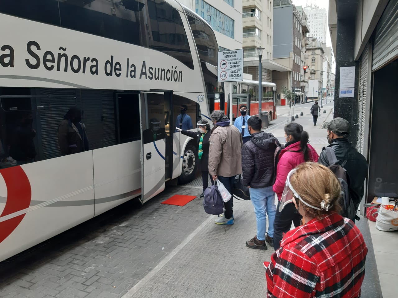 Compatriotas abordando los buses para dirigirse al Paraguay.