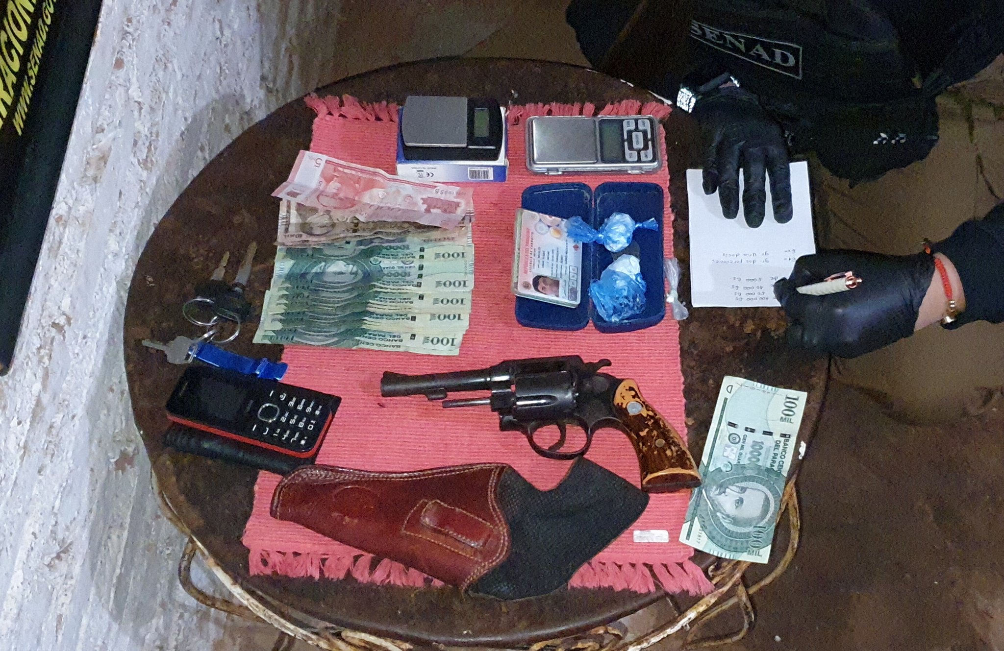 En el lugar fueron hallados cédulas de identidad, arma de fuego, dinero en efectivo y cocaína. Foto: @senad_paraguay
