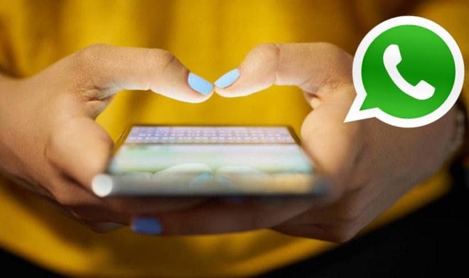 Mujer utilizando su smartphone, solo se ven sus manos y el teléfono. Con el logo de la aplicación Whatsapp.