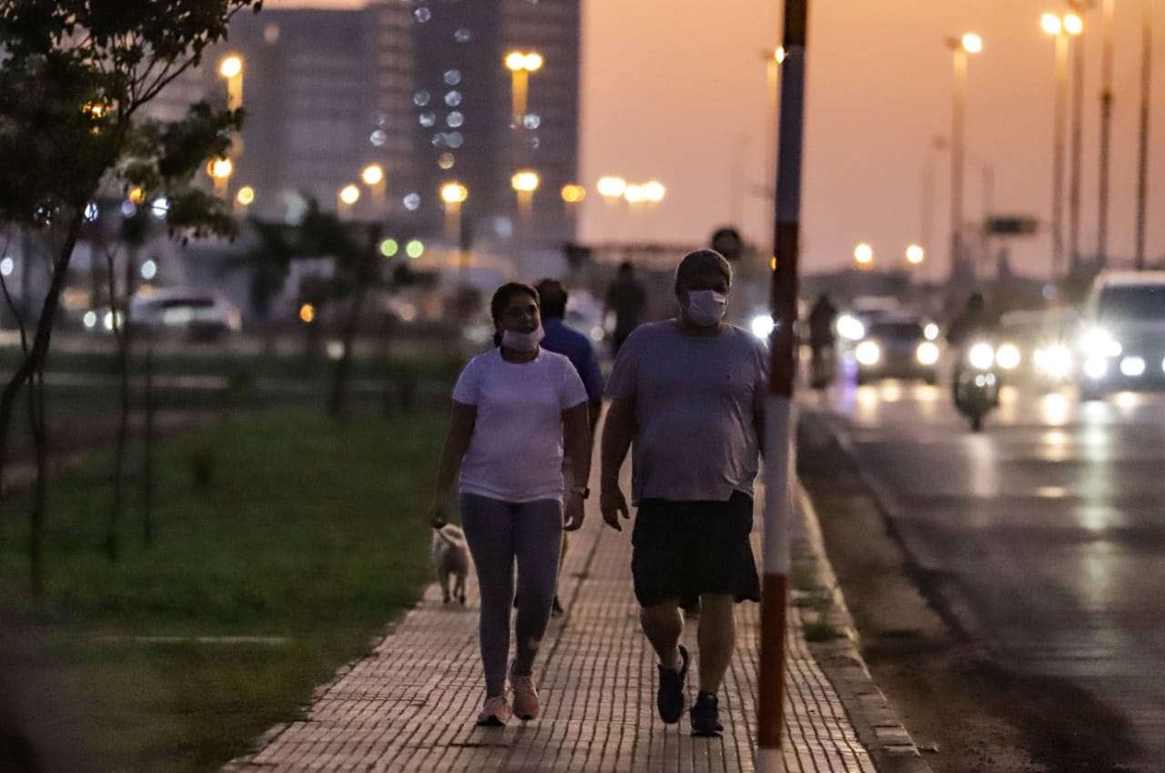 Personas caminando en la costanera de Asunción utilizando tapabocas.
