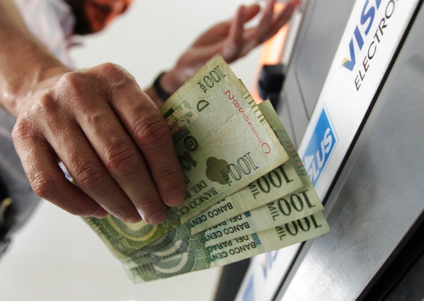 Imagen ilustrativa de una persona sacando dinero de un cajero.