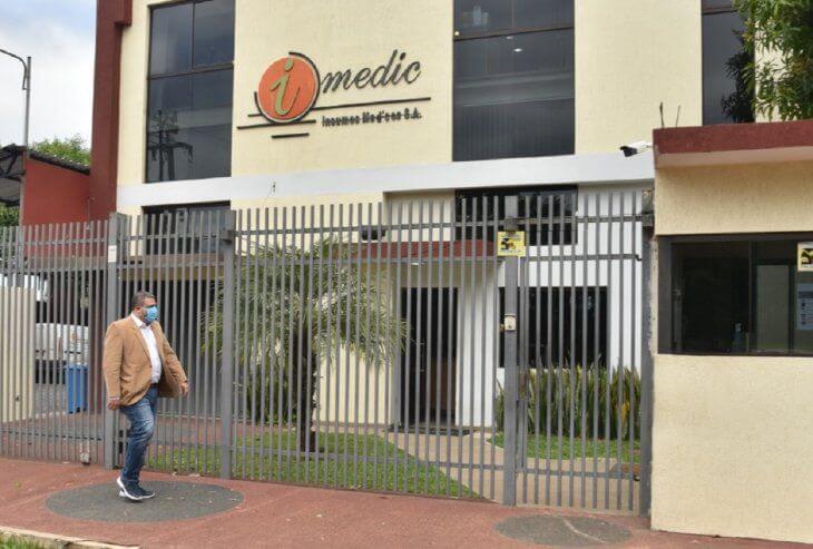 Fachada de empresa IMEDIC, en Asunción. Enfrente pasa una persona usando tapabocas.