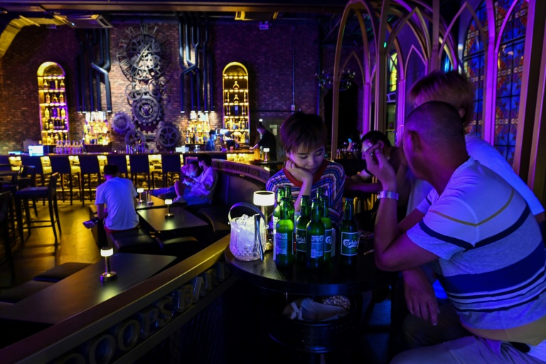 Personas conversan en un bar de Wuhan. Foto: AFP / Héctor Retamal