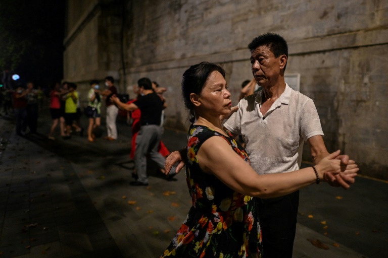 Parejas bailan en la calle cerca del río Yangtsé en Wuhan. Foto: AFP / Héctor Retamal