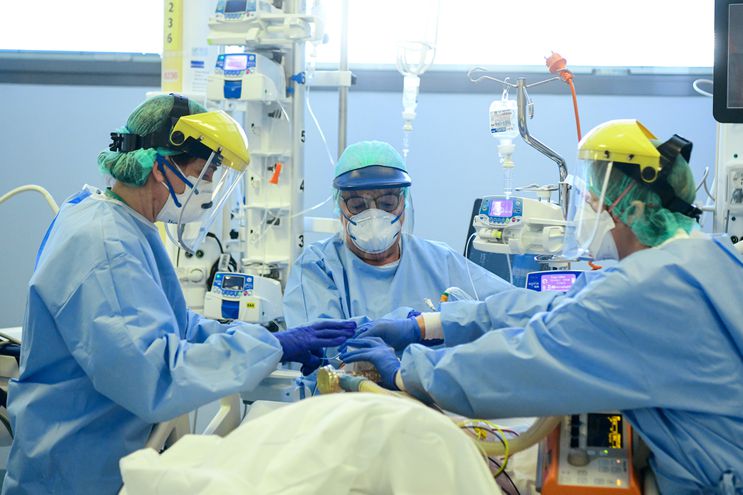 Imagen ilustrativa, personal de salud trabajando con un paciente con respirador.