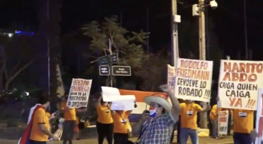 Ciudadanos manifestándose en las calles, con carteles y vistiendo remeras anaranjadas.