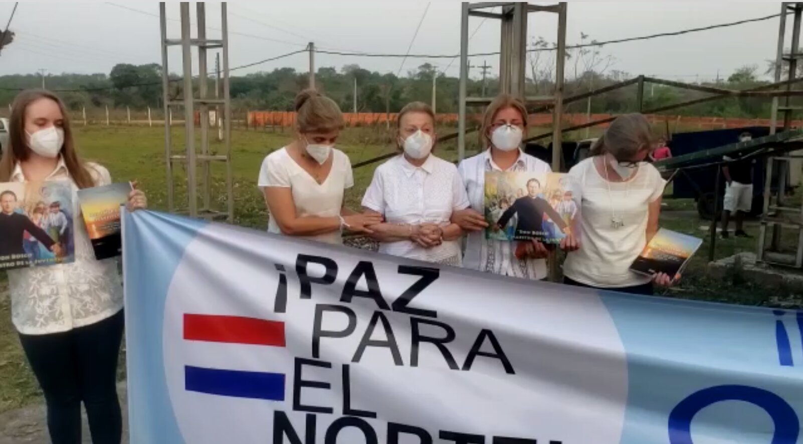 Hijas y esposa de Oscar Denis participando de la automisa, sujetando un cartel que pide la libertad del secuestrado.