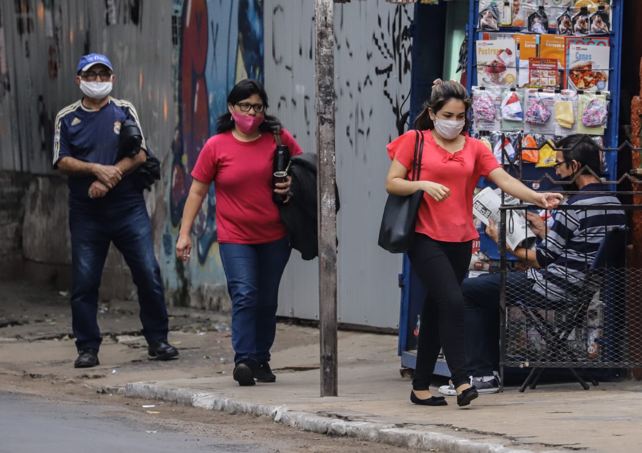 Mujeres caminando y vistiendo tapabocas.