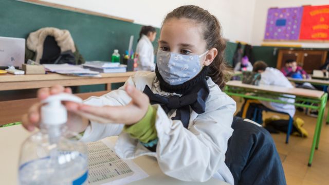 Niña en la escuela con medidas sanitarias.