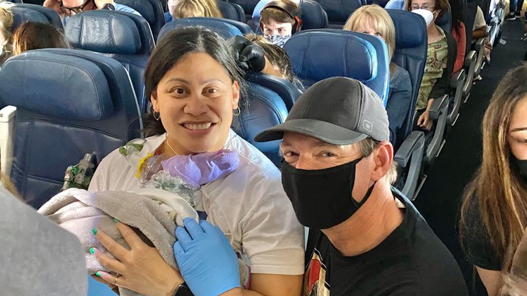 El bebé en manos de la pareja a bordo del avión. Foto: Infobae.